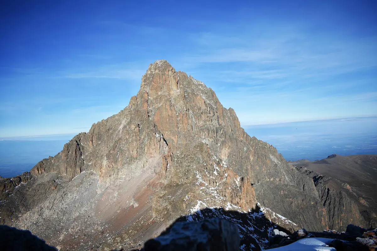Batian pyramid summit seen from Point Lenana above a blue sky