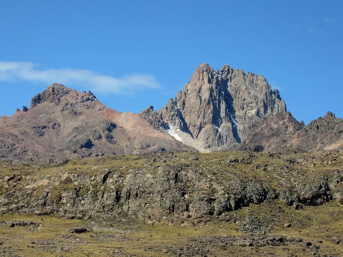 Batian and Nelion rise as jagged rock summits under a clear blue sky