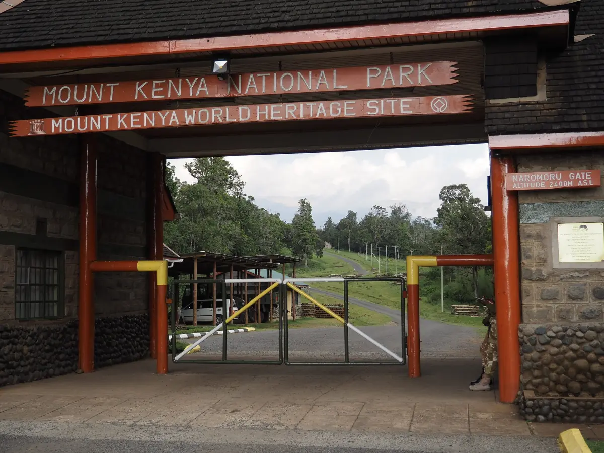 Entrance gate with a wooden sign and barrier at the park boundary