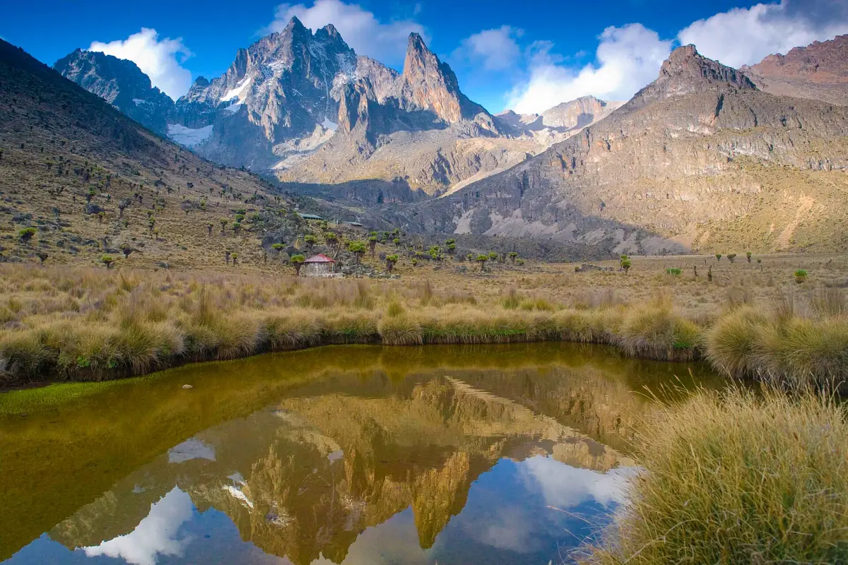 Mountain peaks reflect in a still tarn on the moorland floor